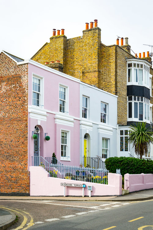 Colourful terrace buildings on a road.