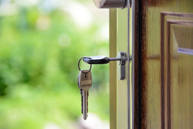 A key in a door keyhole connoting moving of house.