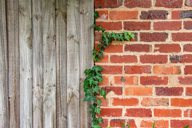A wooden fence attached to a brick wall.